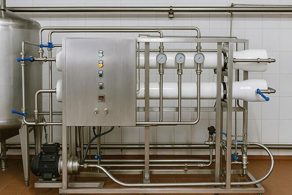 Stainless steel reverse osmosis (RO) system with gauges and control panel in a food-safe manufacturing facility in the UK.